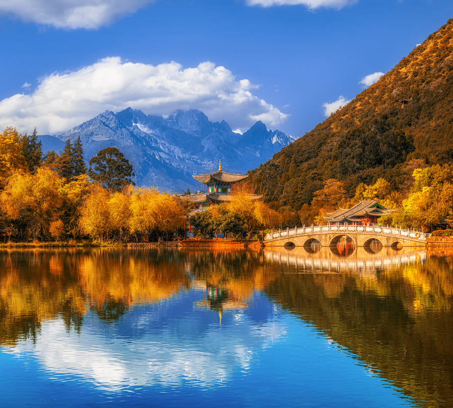 Precioso lago a la orilla de montañas con nubes de fondo en Yunnan China