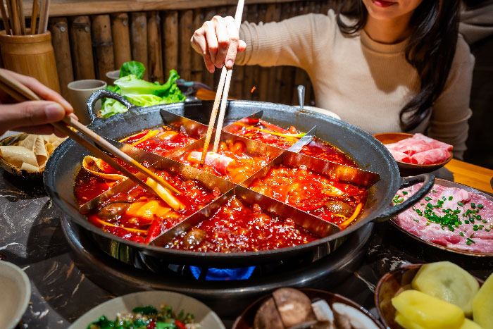 comida tipica de china en cazuelas gigantes, comido con palillos chinos